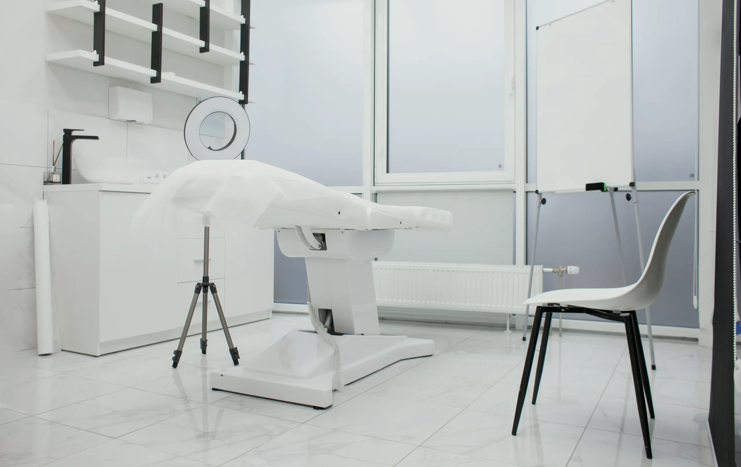 An empty treatment room, daylight from the window, one reclining chair.